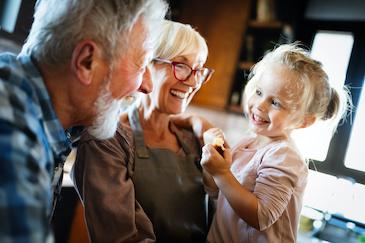 Grandparents cooking with their granddaughter