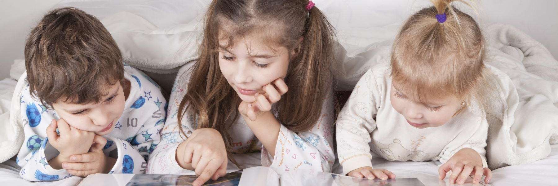Children reading in bed | children's dentist Maple Ridge