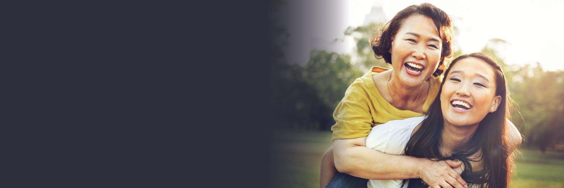 A mother and daughter laughing in the park | dental bone grafting in Maple Ridge