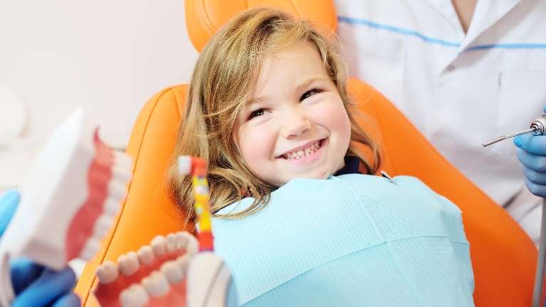 A little white girl smiling while getting a dental check up in Maple Ridge