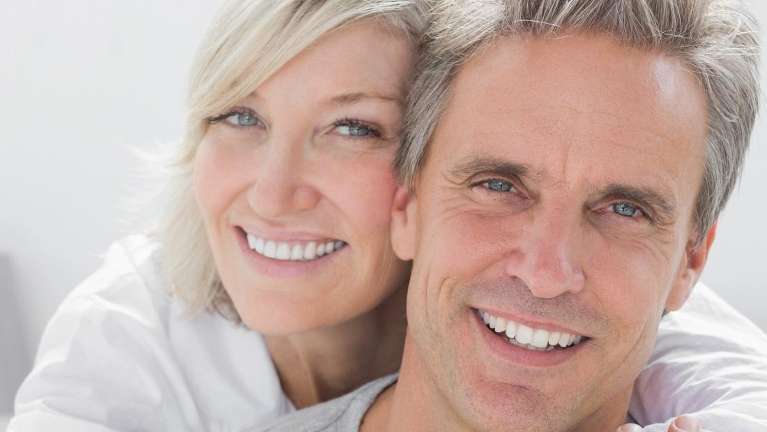 A husband and wife hugging | dental implants Maple Ridge
