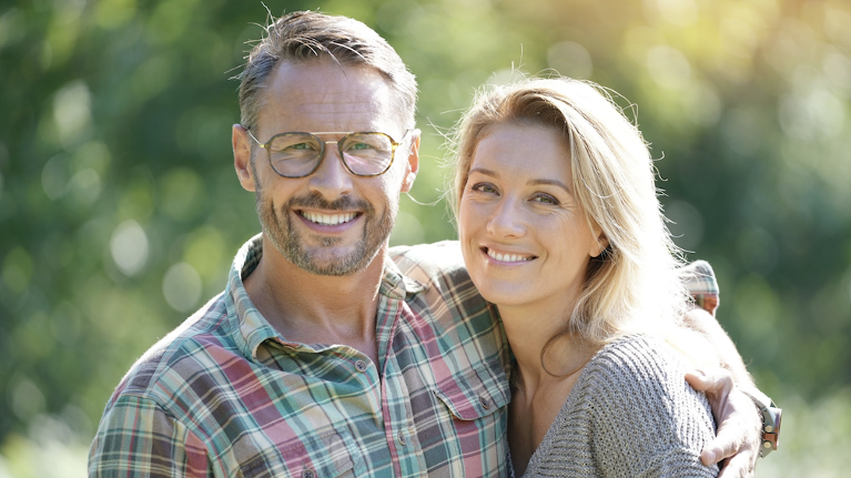A man and a woman smiling after getting Dental Implants in Maple Ridge, BC