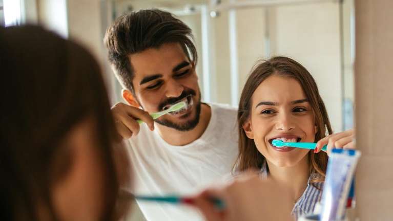 A couple brushing there teeth in Meadow Ridge, BC