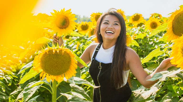 A happy woman in a sunflower field in Maple Ridge, BC