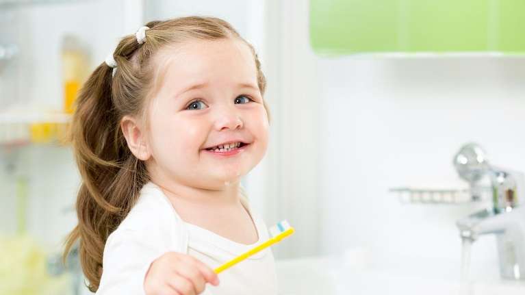 A cute toddler learning to use a tooth brush in maple ridge bc