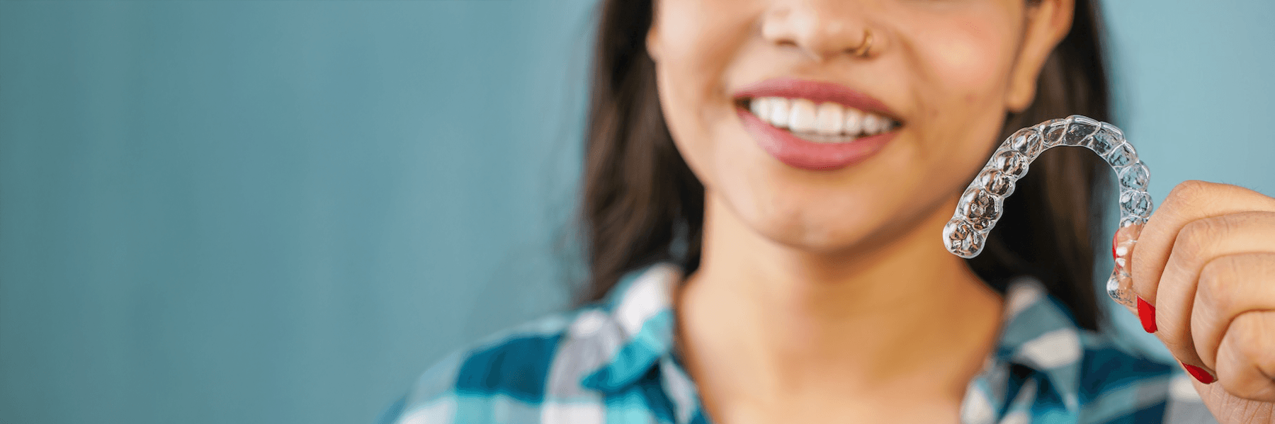 A woman holding a clear aligner in Maple Ridge, BC