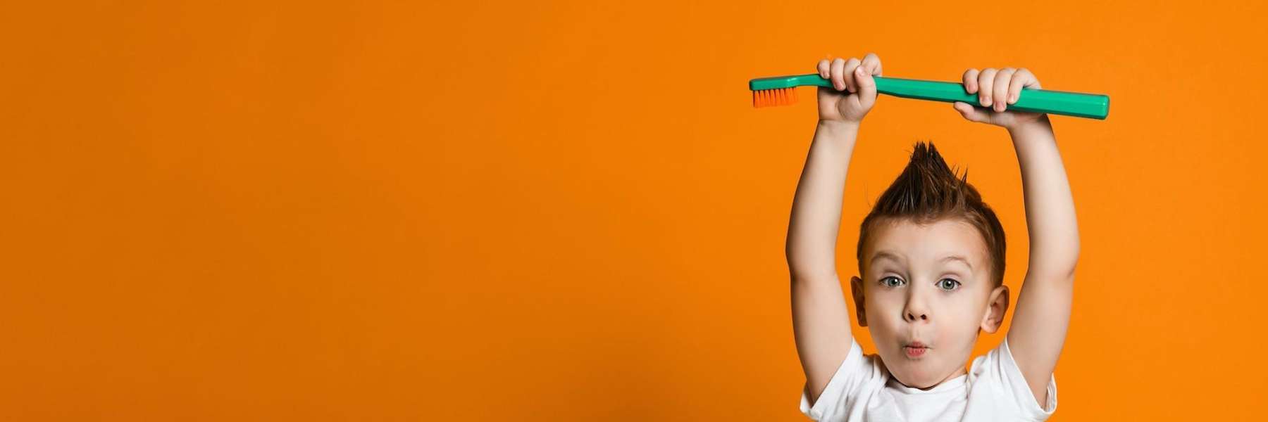 A cute toddler learning to use a tooth brush prop in maple ridge bc